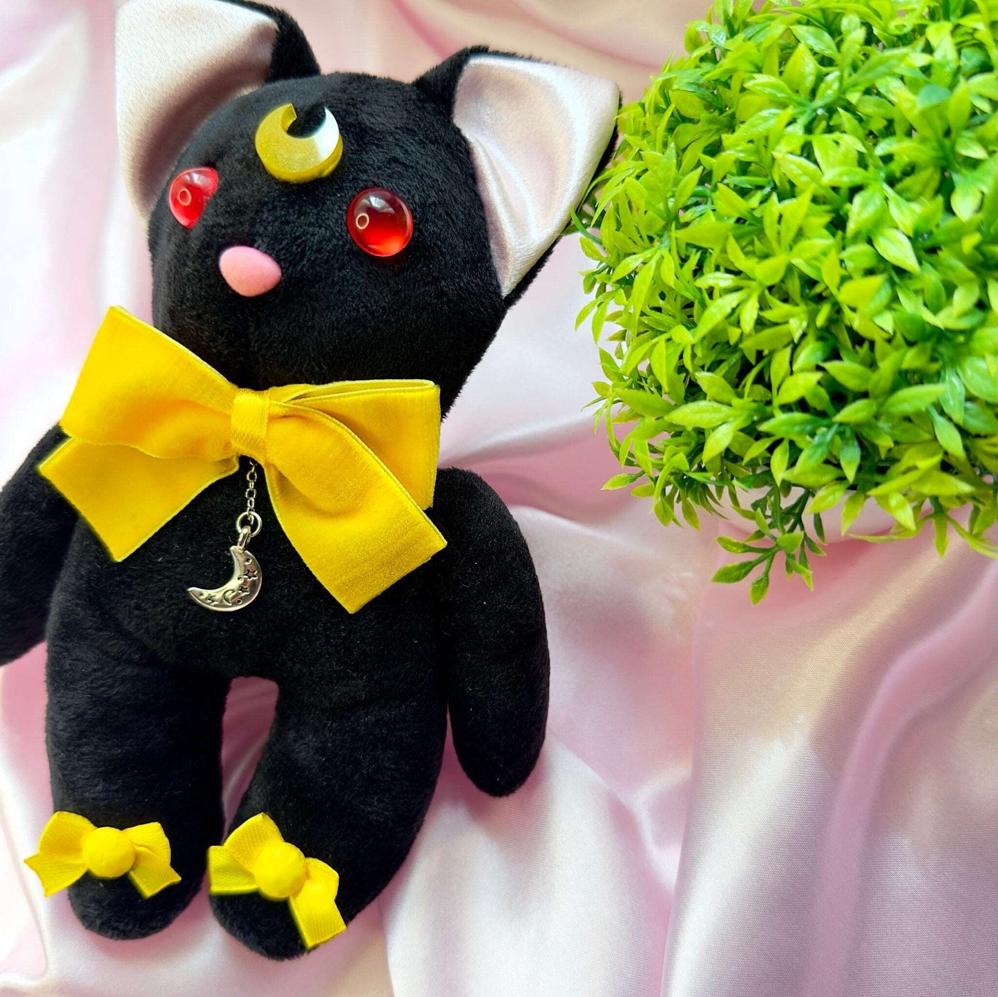 Peluche chat Luna Sailor Moon noire avec nœuds jaunes, lune sur le front et pendentif lune