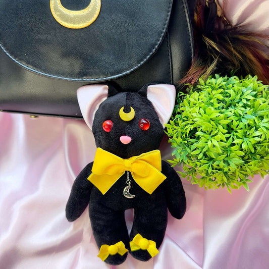 Peluche chat Luna Sailor Moon noire avec nœuds jaunes, lune sur le front et pendentif lune